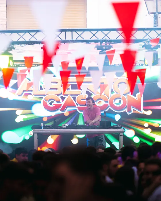 Alberto Gascón en el escenario de unas fiestas, con banderines y público